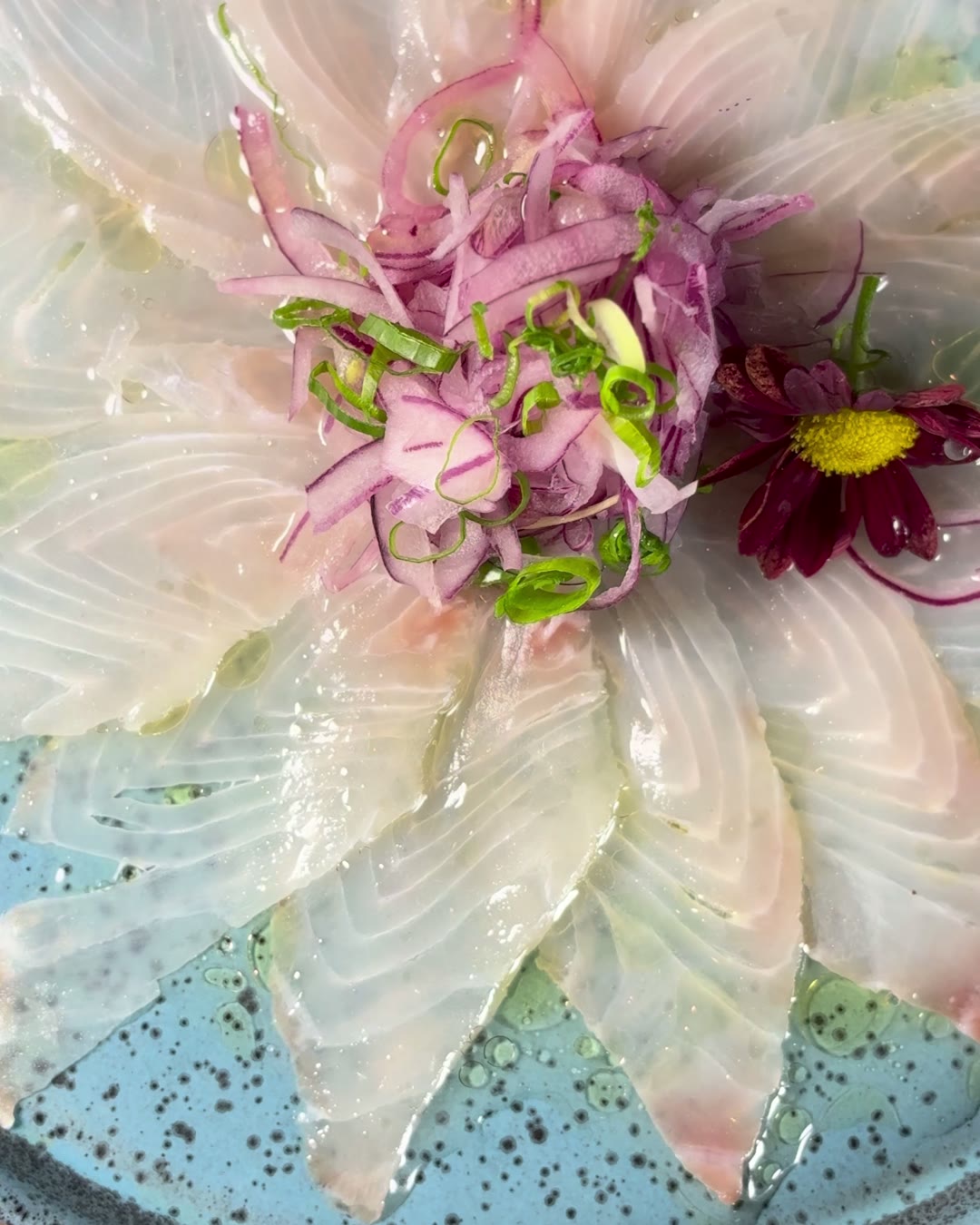 Lâminas finas de peixe branco dispostas em flor