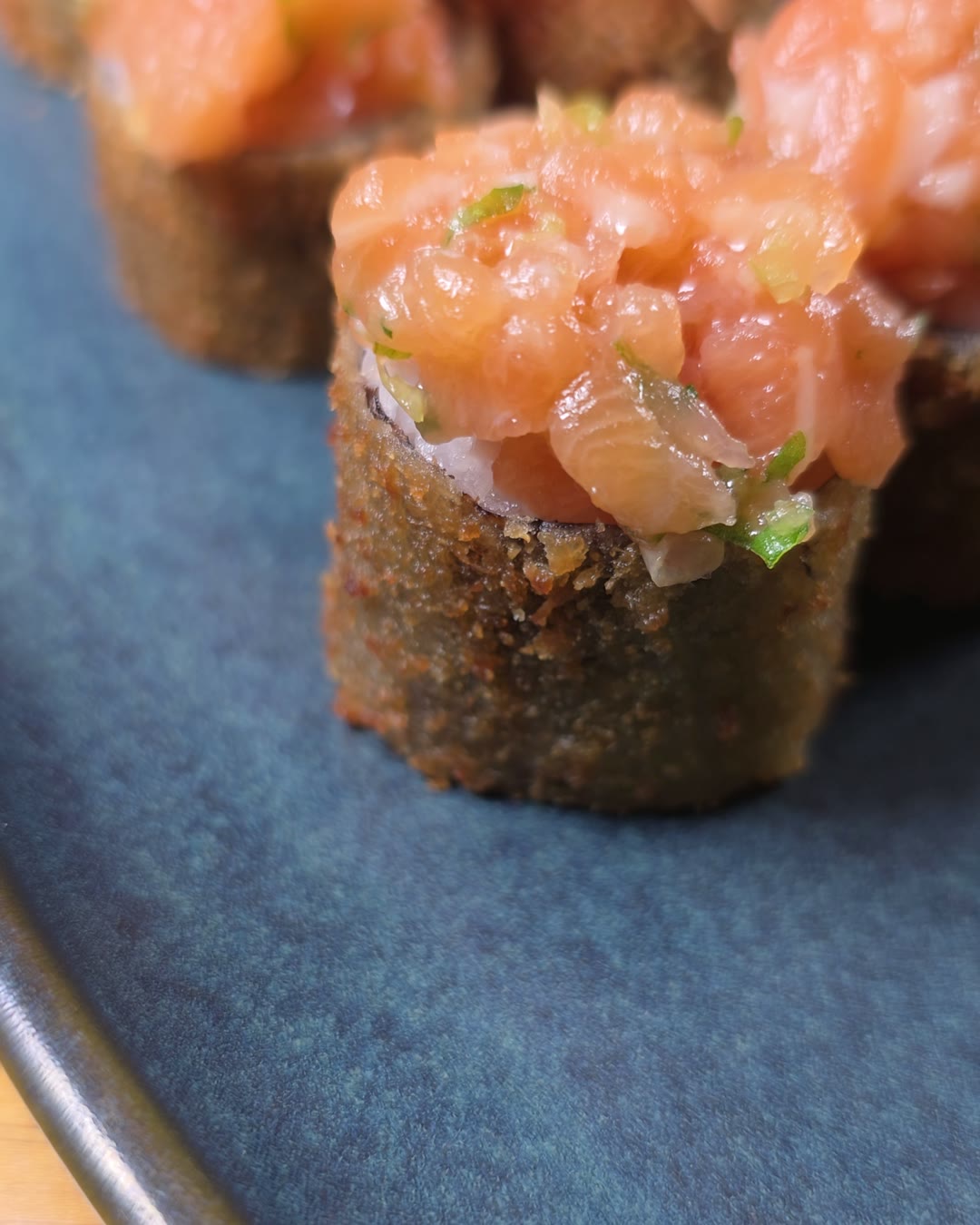 Uramaki empanado coberto com tartar de salmão, de perto